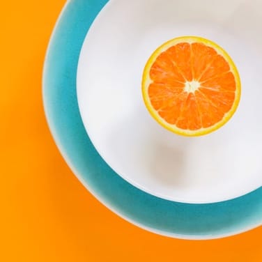 Half of orange on a blue-white plate