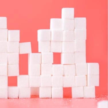 A block of sugar cubes on a pink background