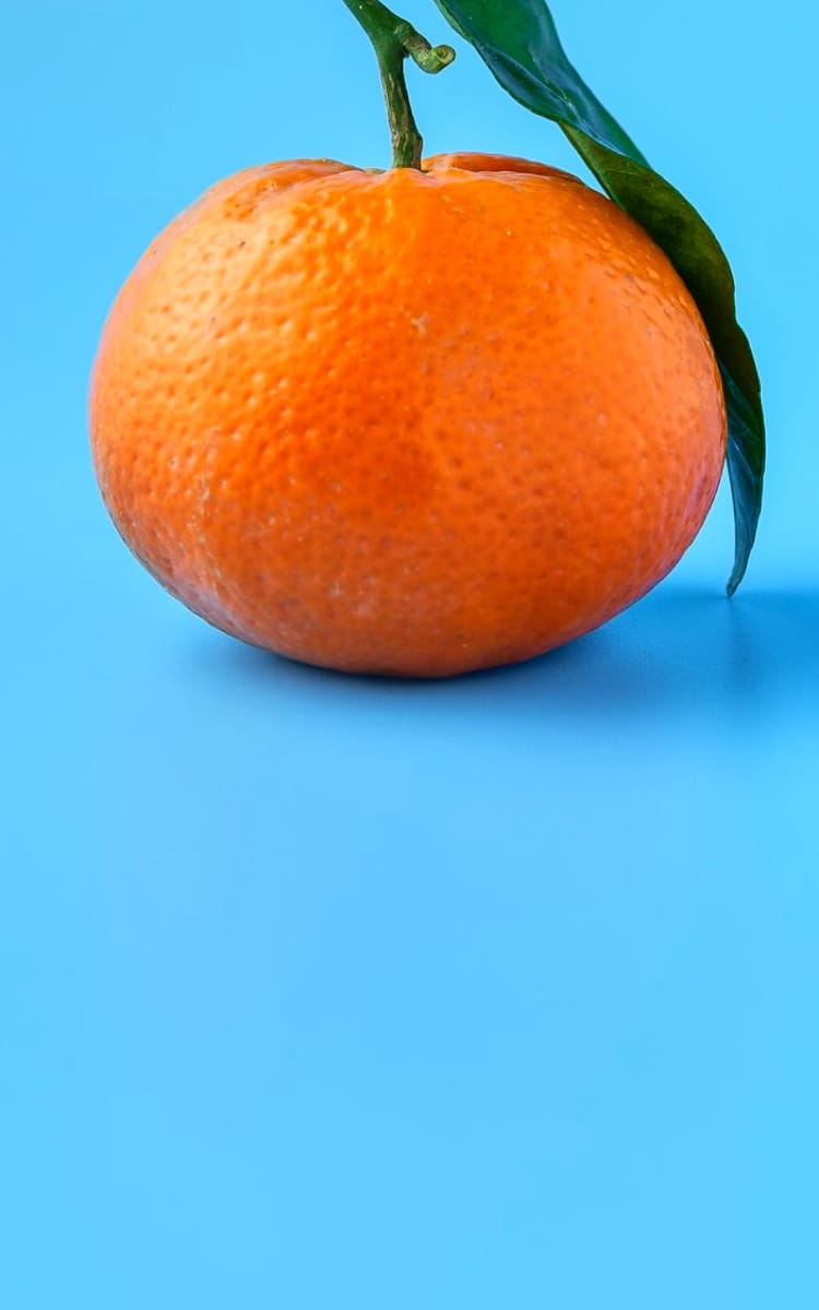 One orange with a green leaf on right side